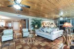 living area with beach decor, sitting chairs, sofa, saltillo tile, wood ceiling, wall mirrors